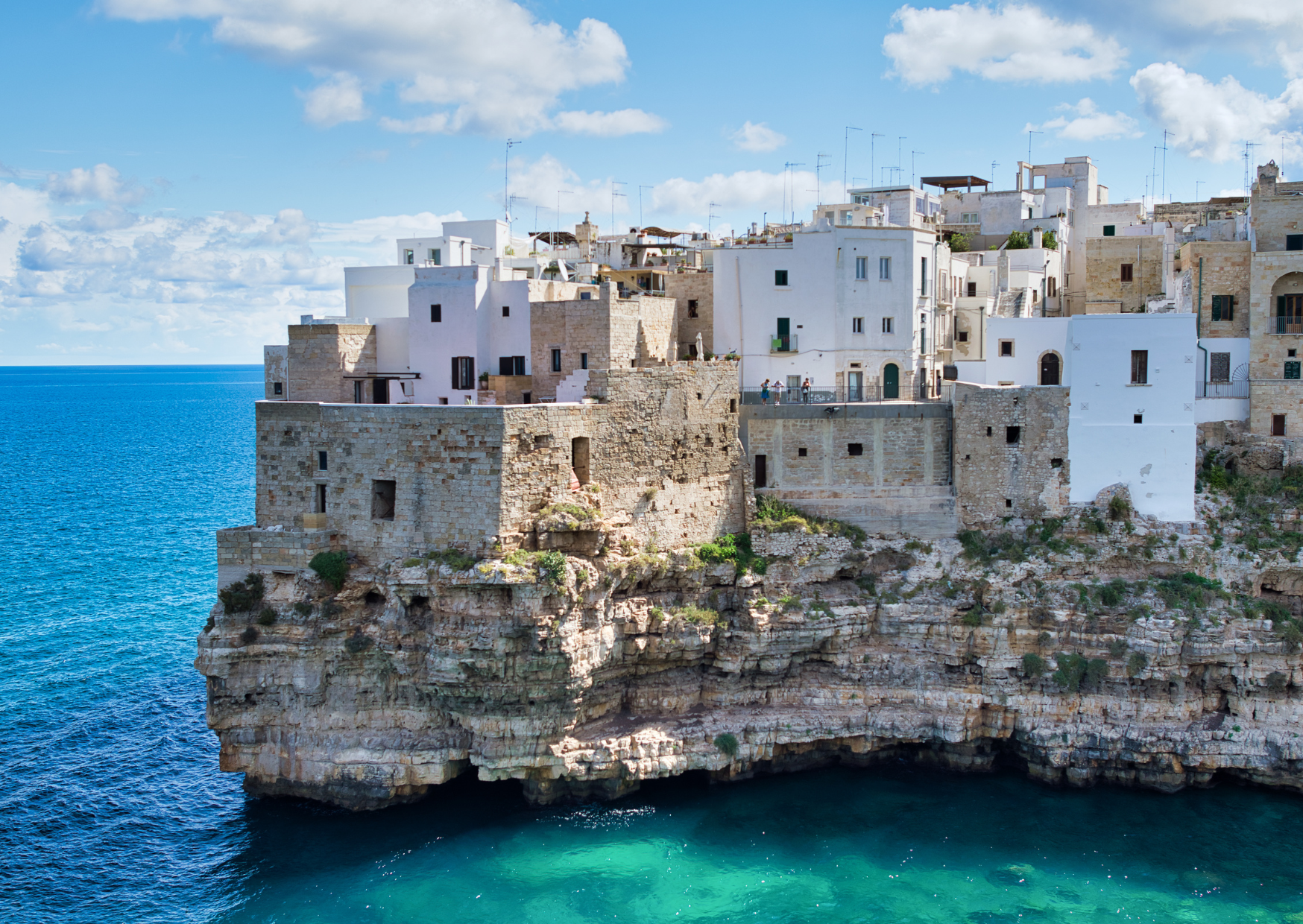 White houses of Polignano a Mare perched on the cliff above the sea