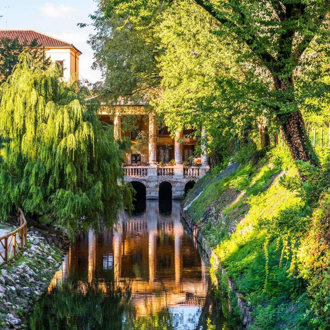 Loggia di una villa affacciata sul canale fra salici e vegetazione