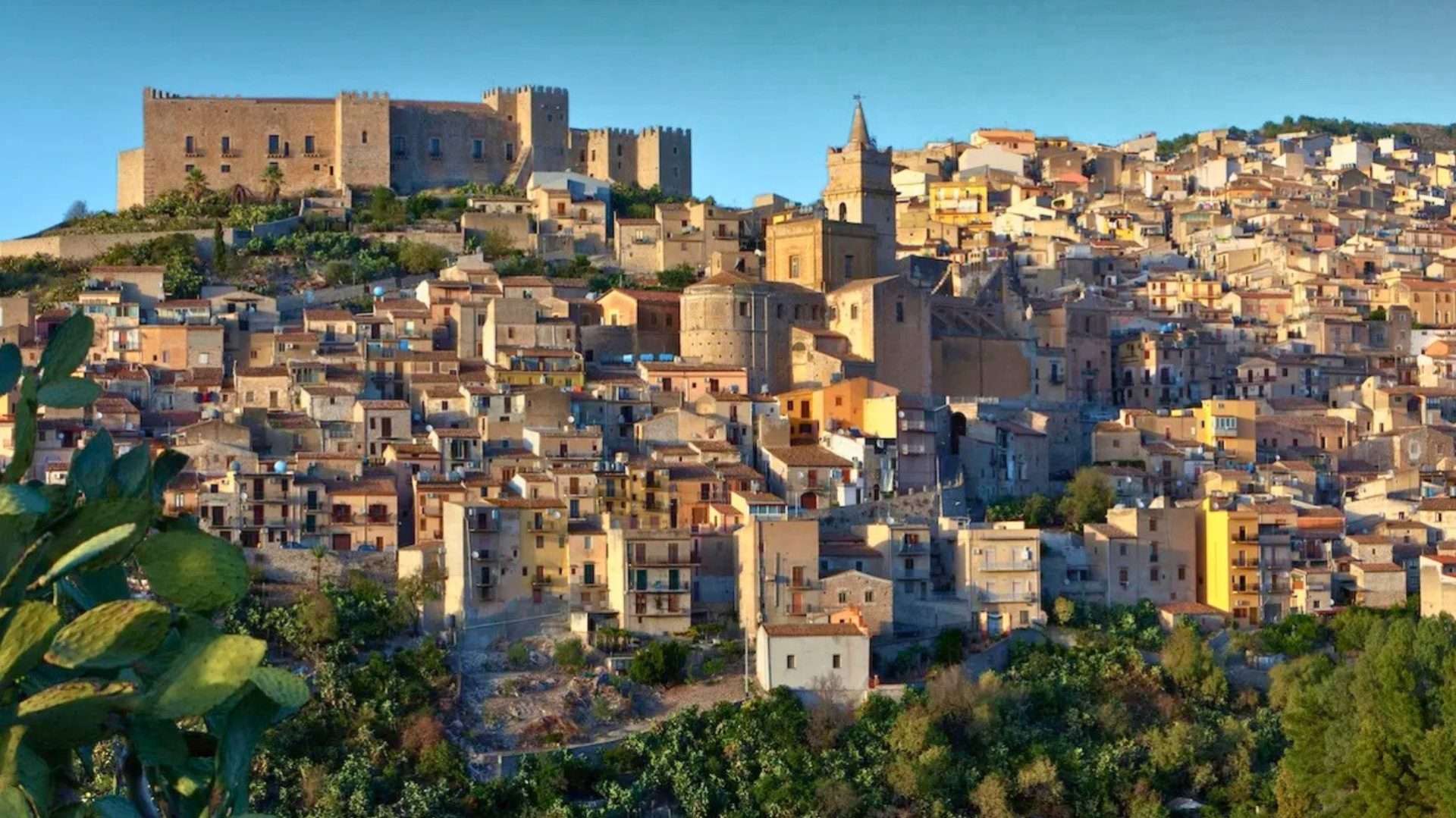 Pueblo siciliano de montaña densamente construido bajo un castillo medieval