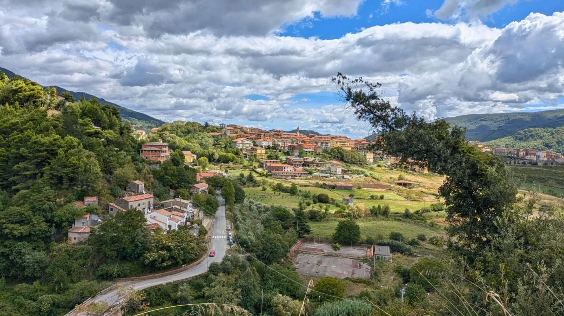 El pueblo de Verbicaro en una ladera verde bajo un cielo nublado