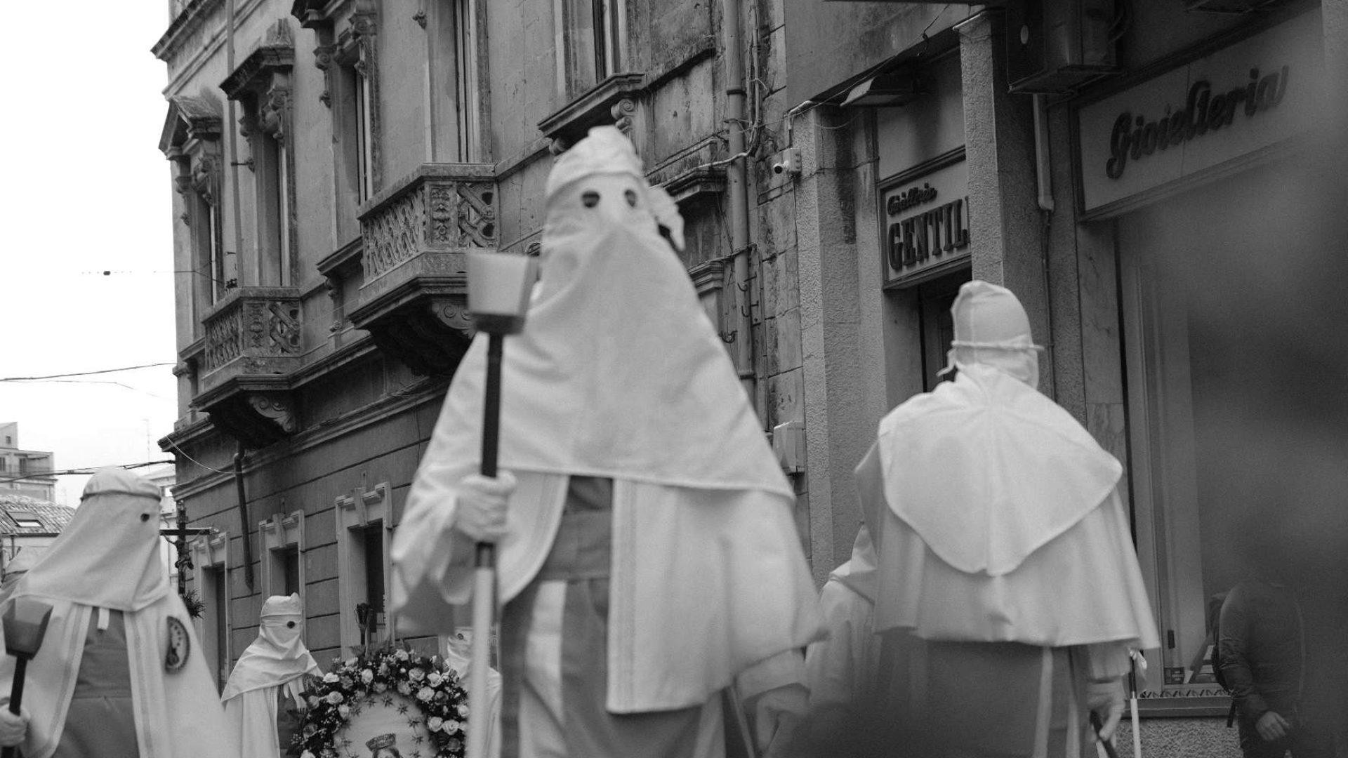 Processione della Settimana Santa nell’ennese: confrati incappucciati in bianco, uno dei riti più intensi per chi vuole trasferirsi in Sicilia